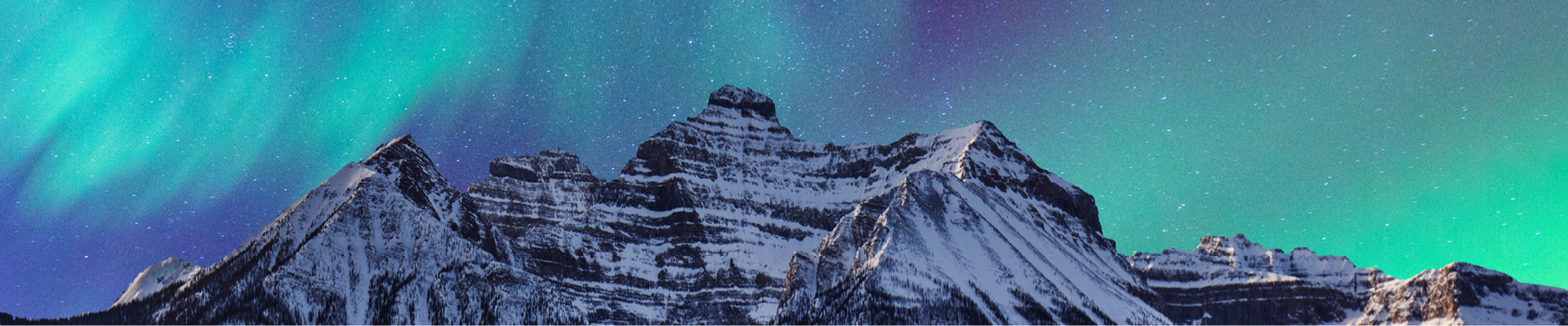 The peak of a snowy mountain with a purple-green Northern Light sky